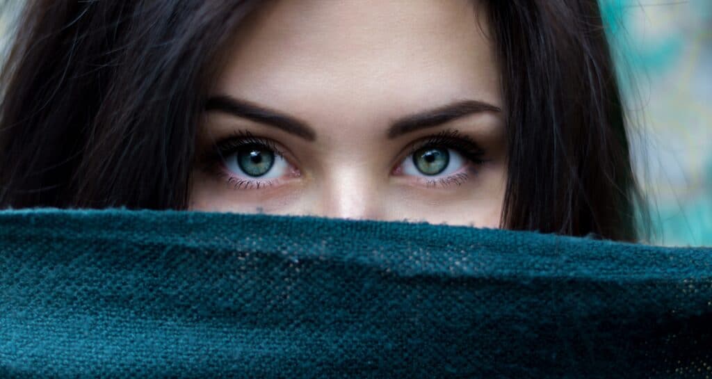 A woman's eyes looking out over a dark scarf