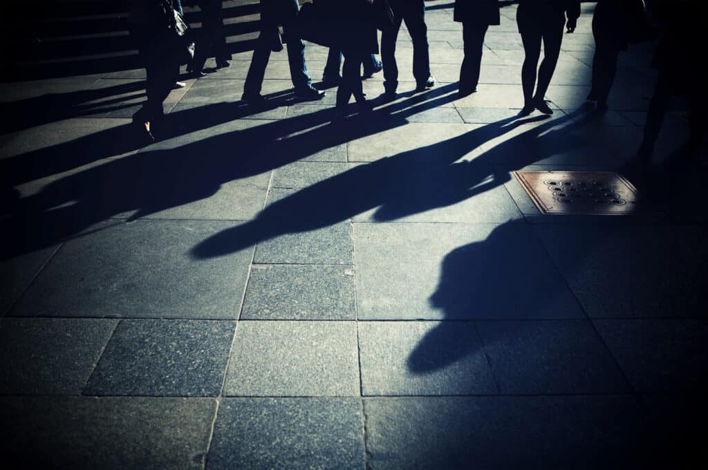 Shadows of people walking, each on their own path